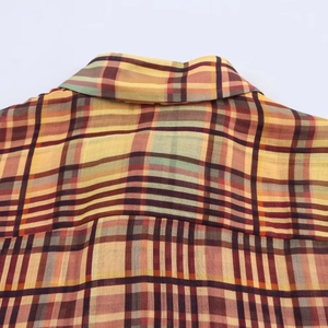 Détail rapproché de la texture du tissu en lin à carreaux multicolores et du col