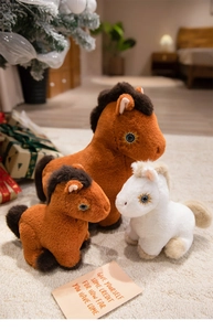 Plush white and brown pony toy set with fine embroidery shown in holiday setting