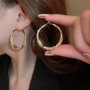 Elegant gold twisted hoop earrings with shimmering crystal pavé detail for women