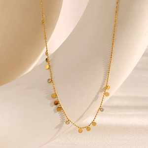 Détail du collier à perles en acier doré 18K avec disques en zircone et breloques rondes