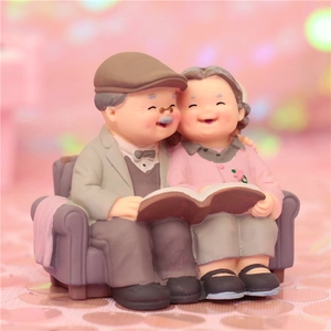 Loving elderly couple resin figurine reading on a sofa for cake or car decor