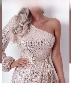 Detail of champagne gold sequins on an elegant one-shoulder evening dress sleeve