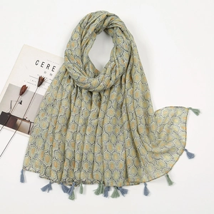 Detail of light green scarf with retro leaf patterns and two-tone tassel fringe