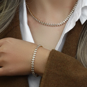 Détail de l'ensemble collier et bracelet tennis doré avec zircone ovale sur modèle