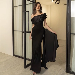 Detail of elegant black one-shoulder evening gown with mesh ribbon and satin texture finish