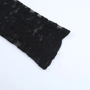 Close-up of black lace fabric with floral patterns and scalloped wave edge detail
