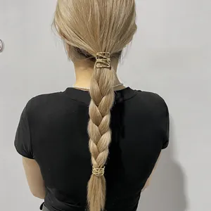 Detail of two-piece hollow gold alloy ponytail buckles on blonde braided hair