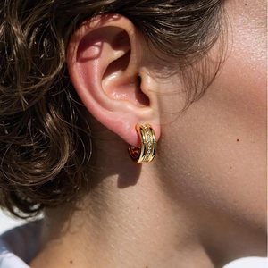 Boucles d'oreilles rétro en C en titane doré avec zircons portées par un mannequin