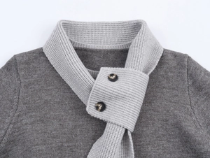 Dettaglio del colletto di un cardigan in maglia grigia con texture a coste e bottoni in legno