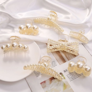 Elegant 7-piece set of pearl hair claws and clips in various shapes on white silk