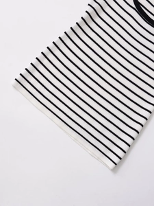 Detailed macro view of the black and white striped knit fabric and hem of the tank top