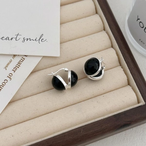 925 Sterling silver hoop earrings with black agate beads on a beige velvet jewelry tray
