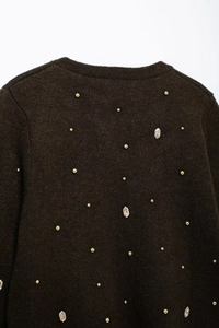 Detail of dark brown knit cardigan featuring scattered gold beads and rhinestones on the back
