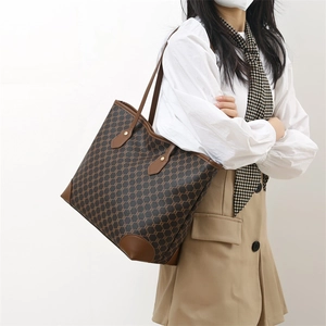 Retro brown monogram large capacity tote bag worn on shoulder by model with clean look