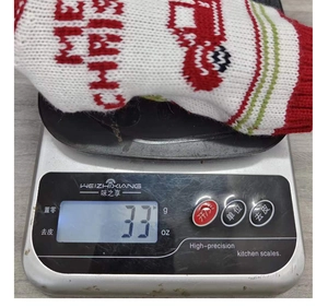 Detail shot of a knitted Christmas wine bottle cover showing festive snowman pattern