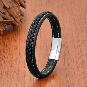 Detail of black woven leather men's bracelet with a polished silver magnetic clasp