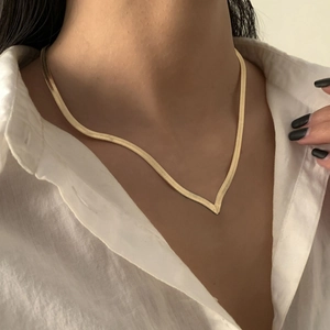 Close-up of a high-quality gold V-shaped snake bone chain necklace on a model