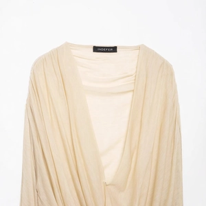 Slim fit beige V-neck long sleeve top with elegant ruched draping and soft texture