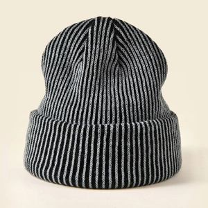 Detail of high-density ribbed knit texture on a black and grey striped winter beanie