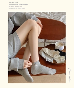 Close-up of cotton socks with puppy embroidery, ribbed cuffs and polka dot texture