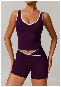 Close-up of purple yoga set featuring cross high waist shorts and white contrast piping