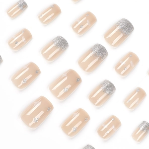 Nude press-on nails with silver glitter gradient and star accents on white background