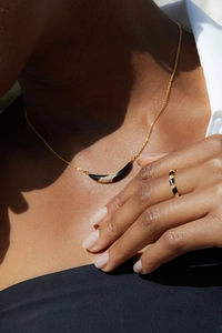 Close-up of 925 silver 18K gold plated black onyx smile necklace and ring on model