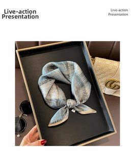Detailed shot of striped silk scarf tied in a bow on a black display tray