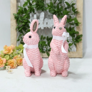 Detail of pink resin bunny set with woven texture and white bows for Easter garden decor
