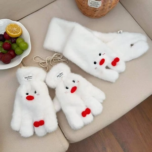 Close-up of white plush scarf and gloves set with cute penguin facial details