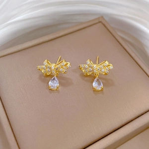 Macro shot of titanium steel bow earrings with pear-cut crystal drops and pave zircons