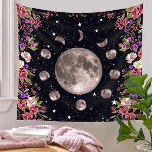 Detail of moon phase tapestry with red floral patterns hanging in a cozy room setting