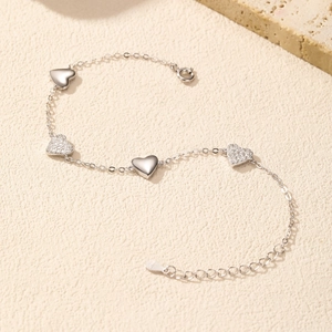 Elegant 925 sterling silver heart bracelet with sparkling crystals on a textured surface