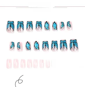 Detailed set of 24 press-on nails with blue glitter butterflies and nude pink finish