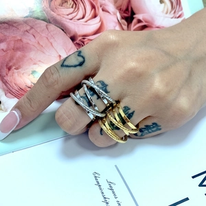 Detail of layered interlocking rings in gold and silver finish with matte and polished texture