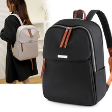 Close-up of nylon backpack in black and light grey with brown faux leather accents