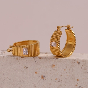 Close-up of gold plated stainless steel earrings with vertical texture and rectangle gemstone