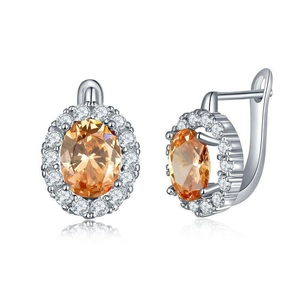 Detail of silver drop earrings with oval orange gemstones and zircon cluster halo