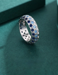 Macro shot of 925 silver ring with blue and white gems and wavy cutout detail