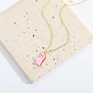 Minimalist golden chain necklace featuring a cute pink dinosaur pendant on marble surface