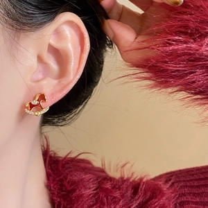 Detail eines 18k vergoldeten Schaukelpferd-Ohrrings mit roter Emaille und Zirkon-Steinen