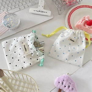 Close-up of cute cotton drawstring storage pouches with heart prints and brand label
