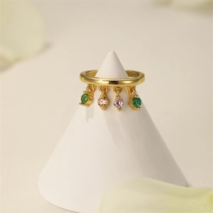 Detail view of a gold ring with multi-colored gemstone charms on a white display cone