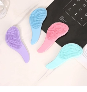 Flat lay of macaron-colored marble detangling hairbrushes in purple, blue, pink and green