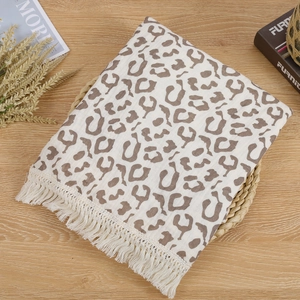 Macro detail of leopard print cotton muslin baby blanket with delicate fringe edges