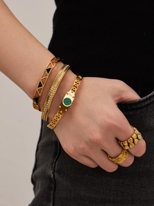 Detail of 18k gold plated bracelets with malachite inlay and geometric hollow design