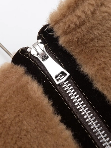 Detail of brown faux fur and black suede junction with premium silver metal zipper