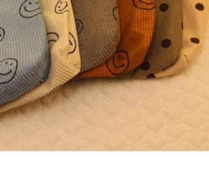 Detail of corduroy makeup bags with smiley faces and polka dots in various colors