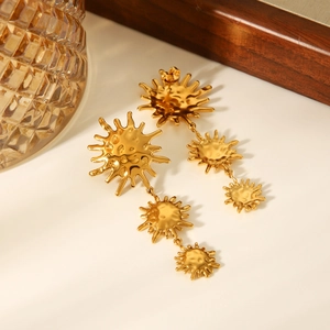 Detailed view of 18k gold sun pendant drop earrings with textured hammer finish details