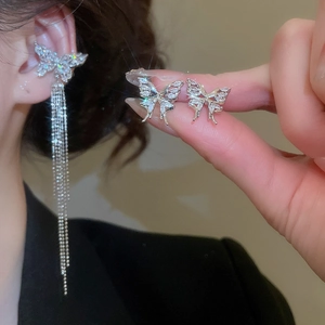 Close-up of elegant silver butterfly ear cuff with zircon tassels and long chain detail
